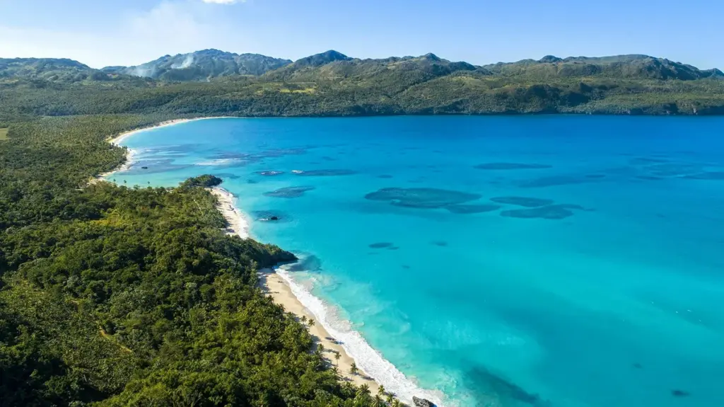 Vista aérea de una playa de arena blanca con agua turquesa y selva en la península de Samaná