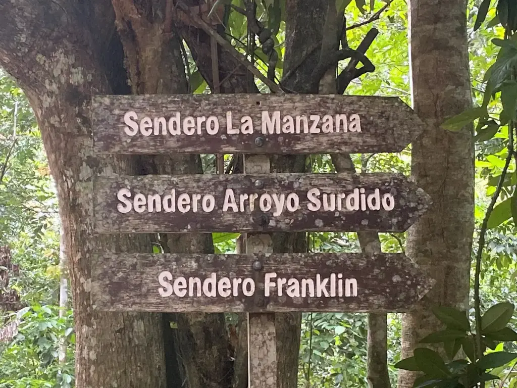 Carteles de madera que indican los senderos La Manzana, Arroyo Surdido y Franklin hacia el Salto El Limón