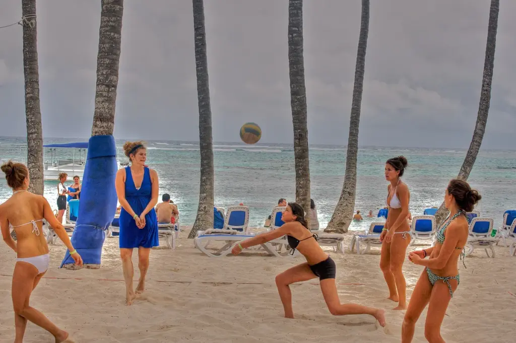 Grupo jugando voleibol de playa entre palmeras en Club Med Punta Cana