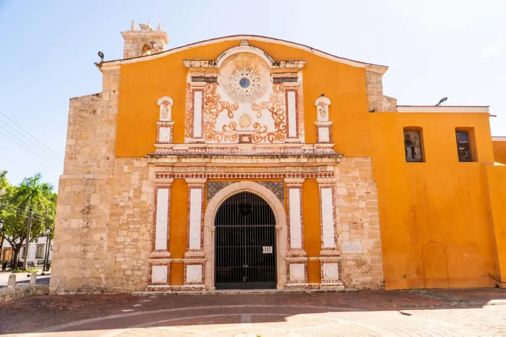 Fachada de la Iglesia de los Dominicos con portada de piedra y muros color terracota en la Zona Colonial