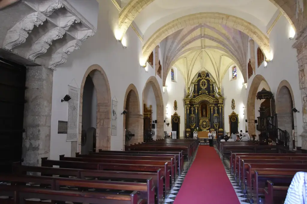 Nave central de la Iglesia de los Dominicos con bóvedas góticas y retablo dorado al fondo