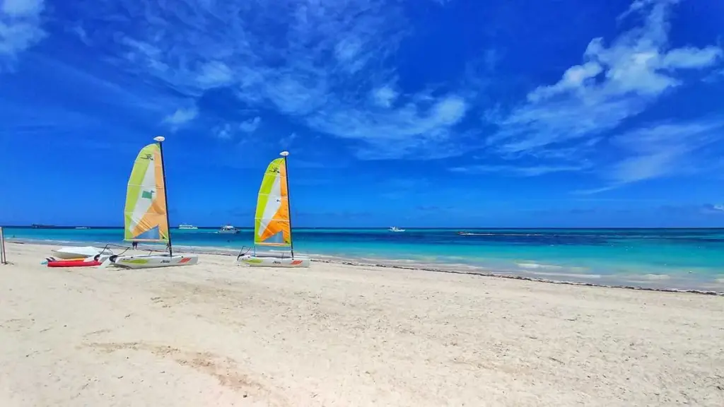 Arena blanca y mar turquesa en Playa Bávaro con veleros en la orilla
