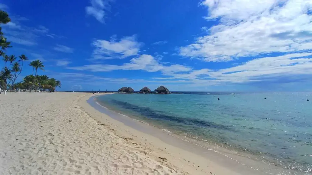 Playa de Guayacanes con arena clara, agua tranquila y pequeños islotes al fondo