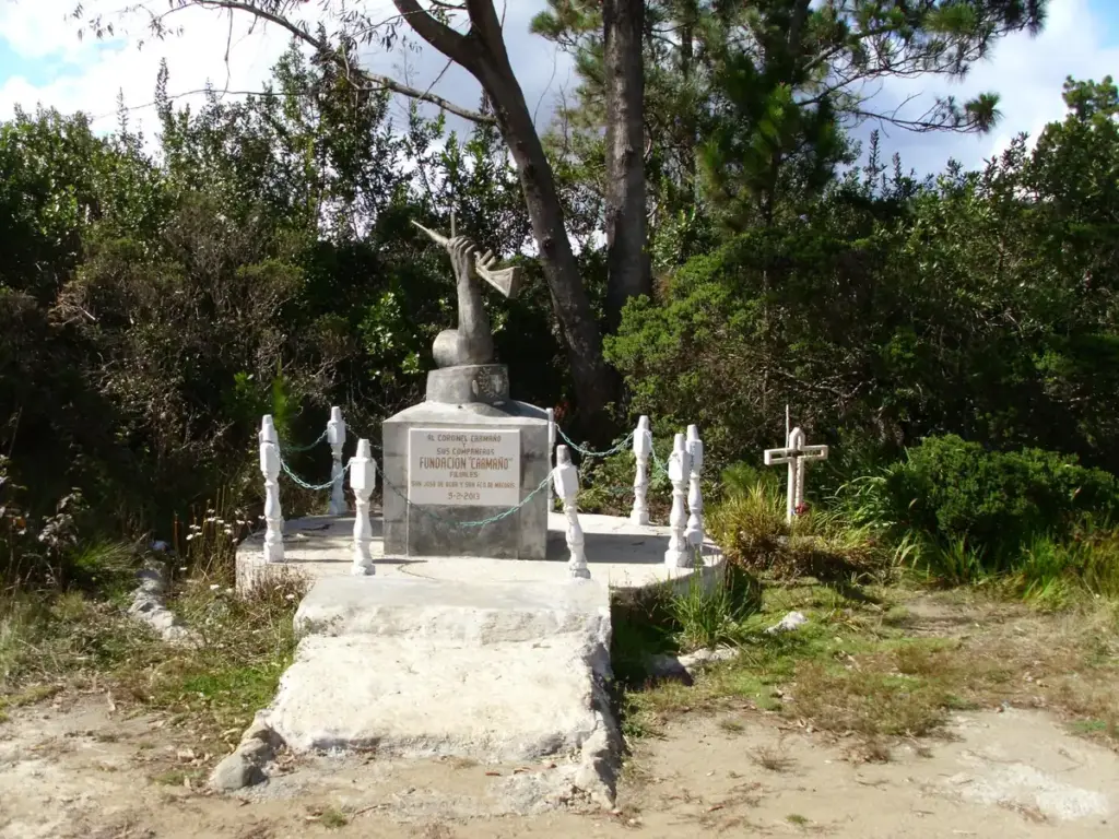 Monumento conmemorativo de piedra blanca entre pinos en el Parque Nacional Valle Nuevo