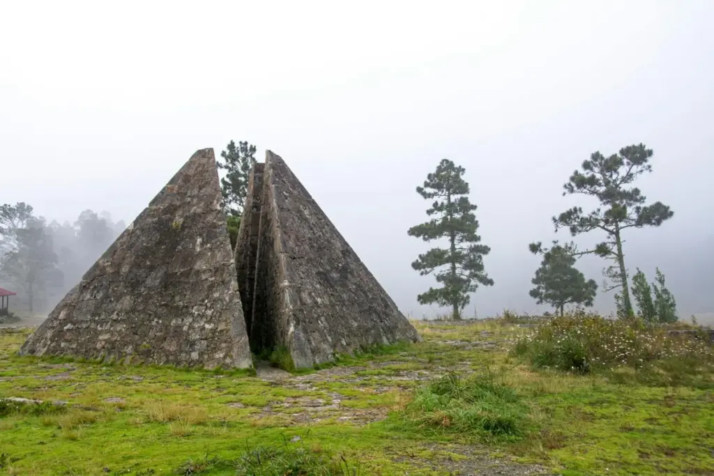 Pirámide de piedra partida en la sabana de Valle Nuevo con pinos y bruma al fondo