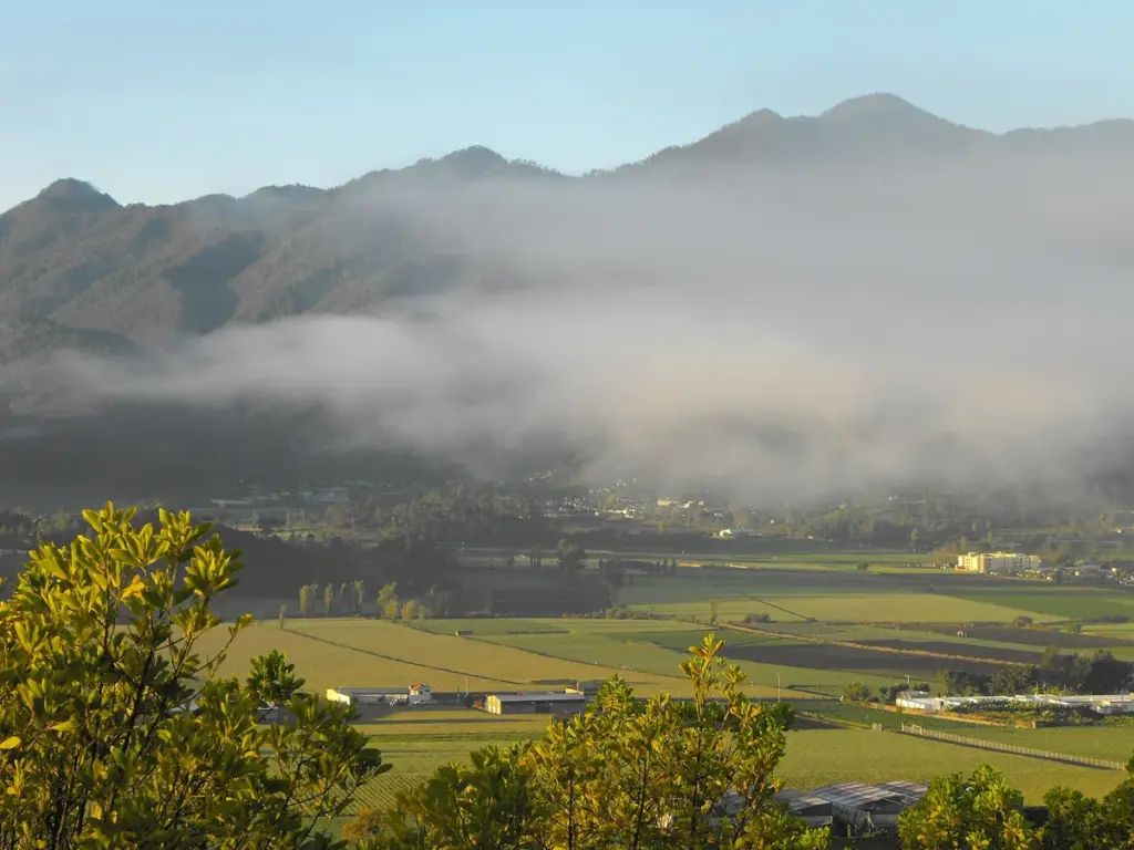 Valle de Constanza con niebla entre las montañas y campos de cultivo