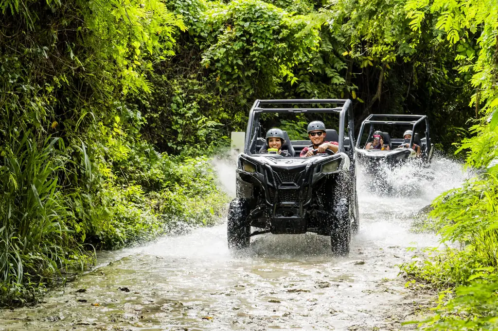 Dos vehículos todoterreno cruzando un arroyo en la selva cerca de Punta Cana