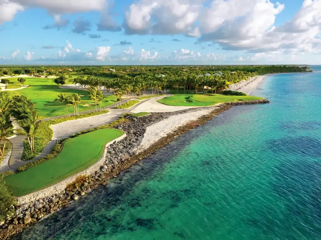 Vista aérea de un campo de golf junto al mar turquesa en Punta Cana