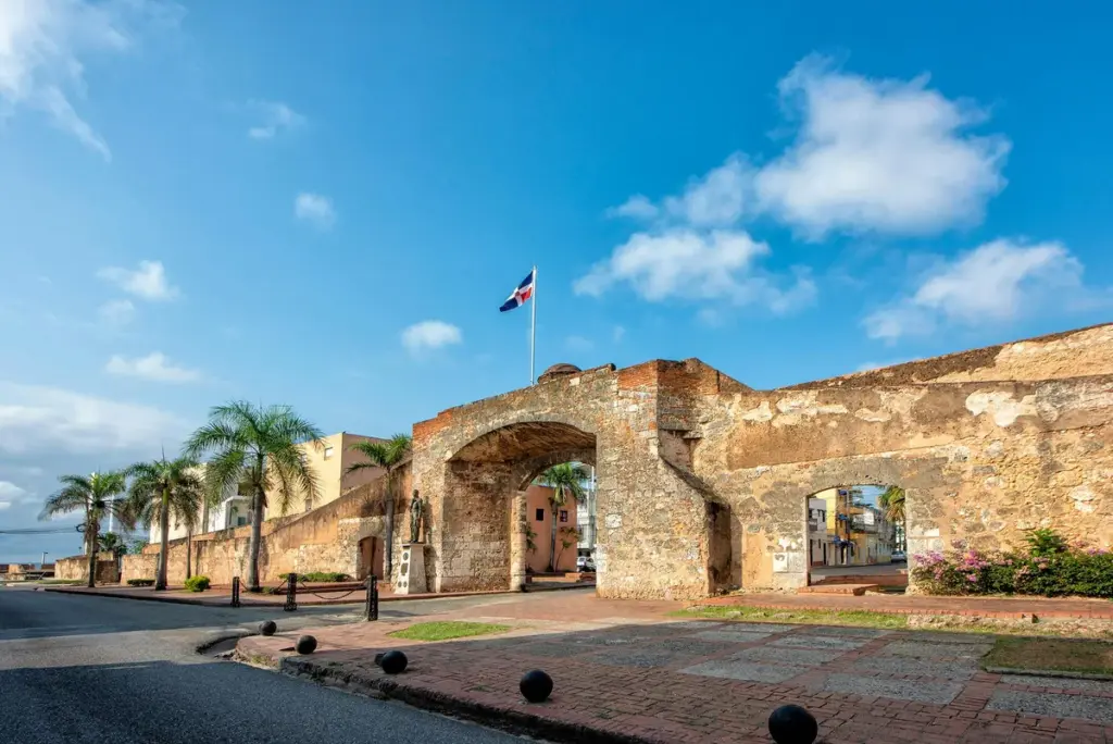 Antigua puerta y muralla de piedra de la Ciudad Colonial con la bandera dominicana