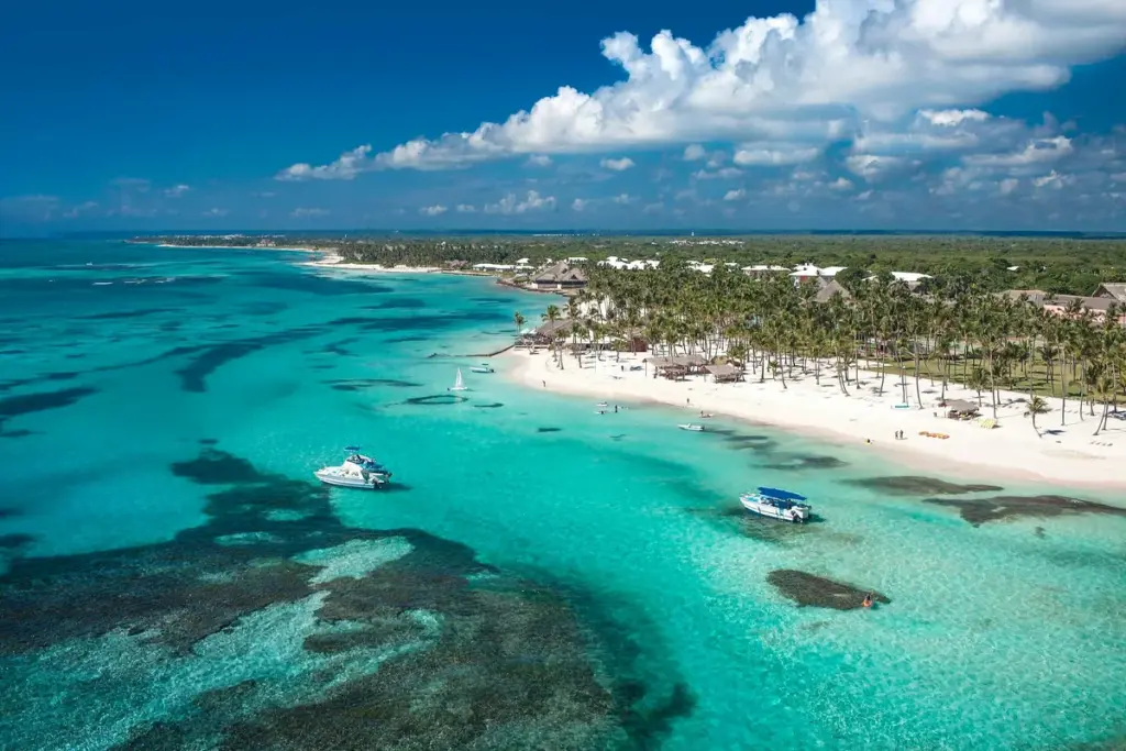 Vista aérea de la playa y el arrecife turquesa frente a un resort de Punta Cana