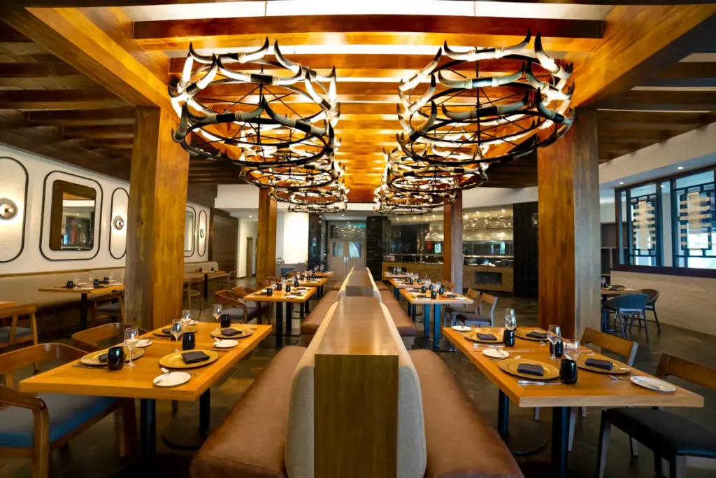 Interior del restaurante Hunter Steakhouse con mesas de madera y lámparas colgantes