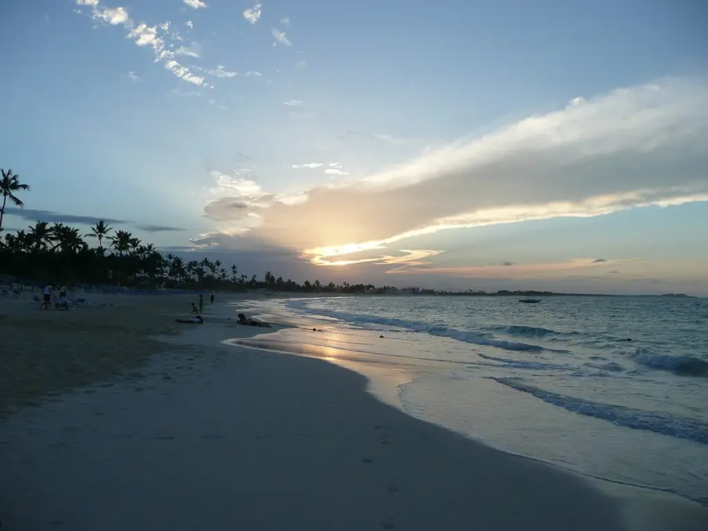 Atardecer sobre una playa de Punta Cana con palmeras en el horizonte