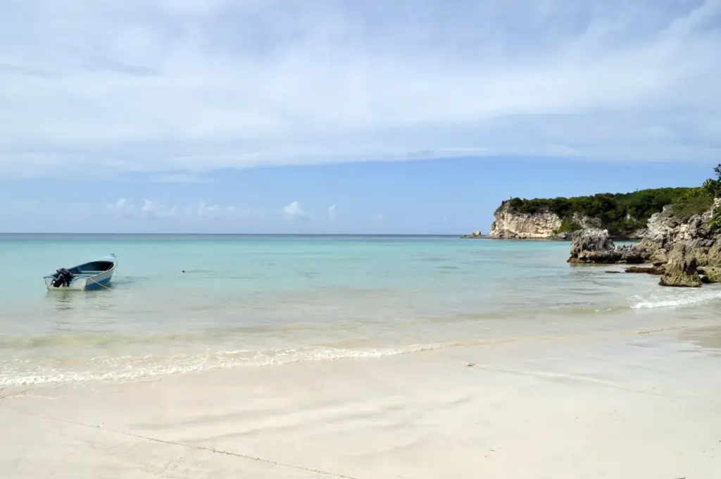 Playa Macao con arena blanca, agua cristalina y un acantilado verde al fondo