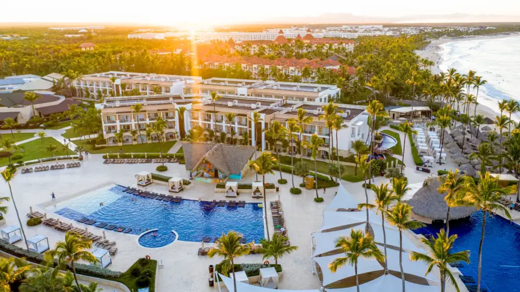 Vista aérea al atardecer del Royalton Punta Cana con piscinas, jardines y la playa de Arena Gorda