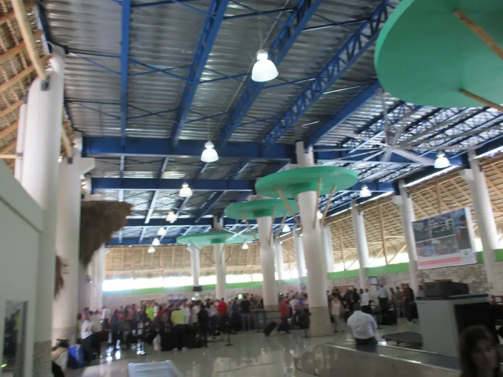 Sala de llegadas del Aeropuerto Internacional de Punta Cana con techos altos y columnas